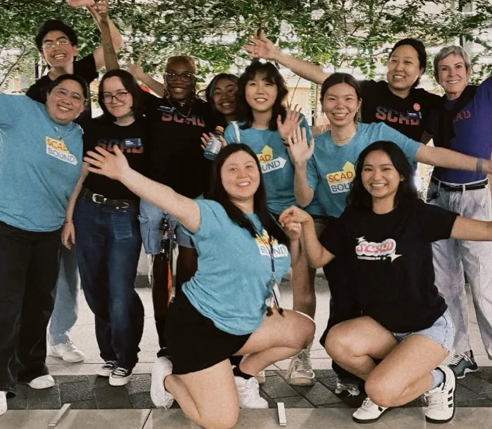 International Orientation team cheering with hands raised at game night