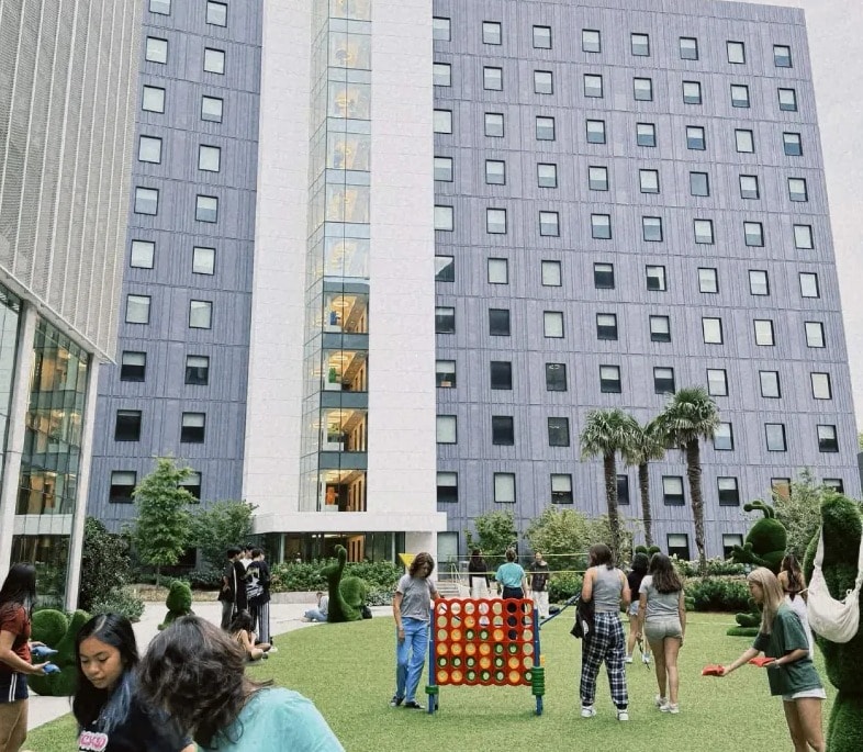 Students playing lawn games on SCAD Court in front of the residence hall