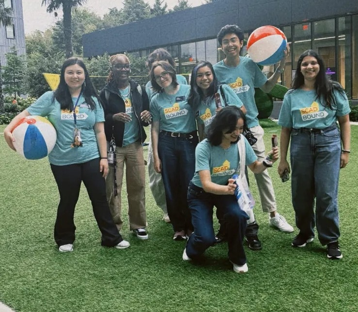 International Orientation team posing with beach balls outside the residence hall
