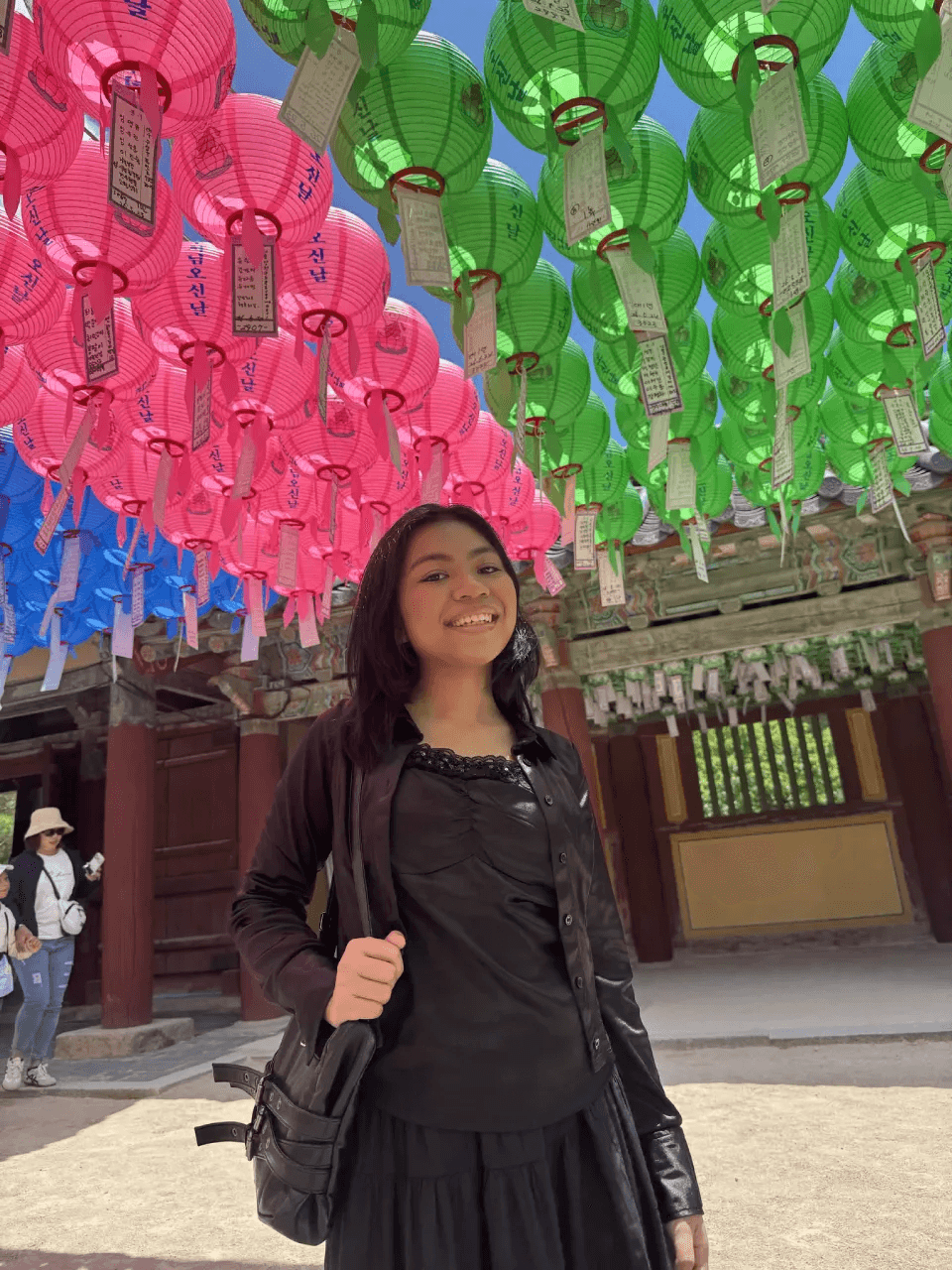 Audrey smiling under pink and green paper lanterns